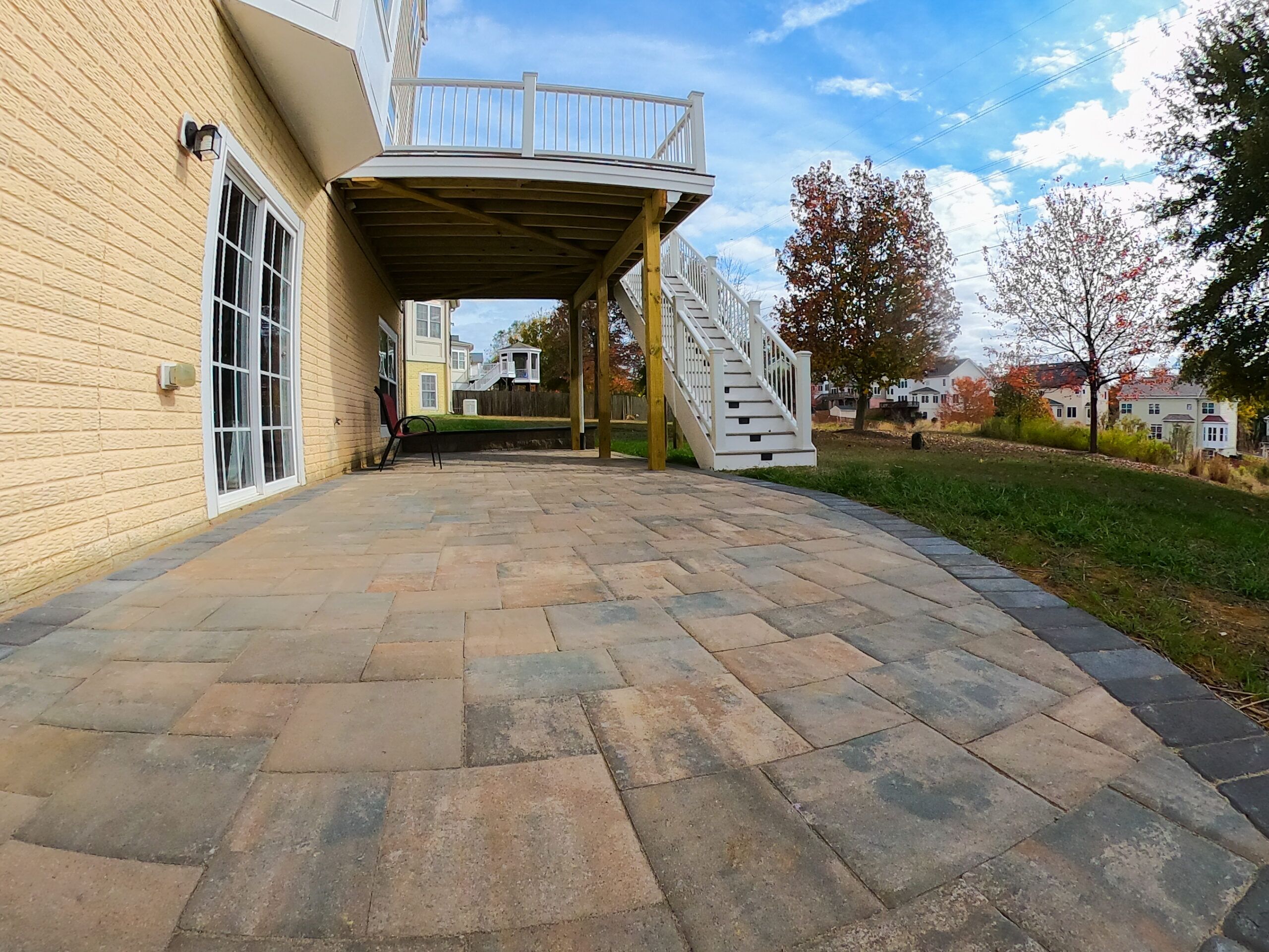 Custom patio pavers at the bottom and a stairway that goes up to the top floor to a Trex Deck